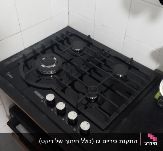כיריים גז שחורות עם ארבעה מבערים וכפתורי שליטה כסופים